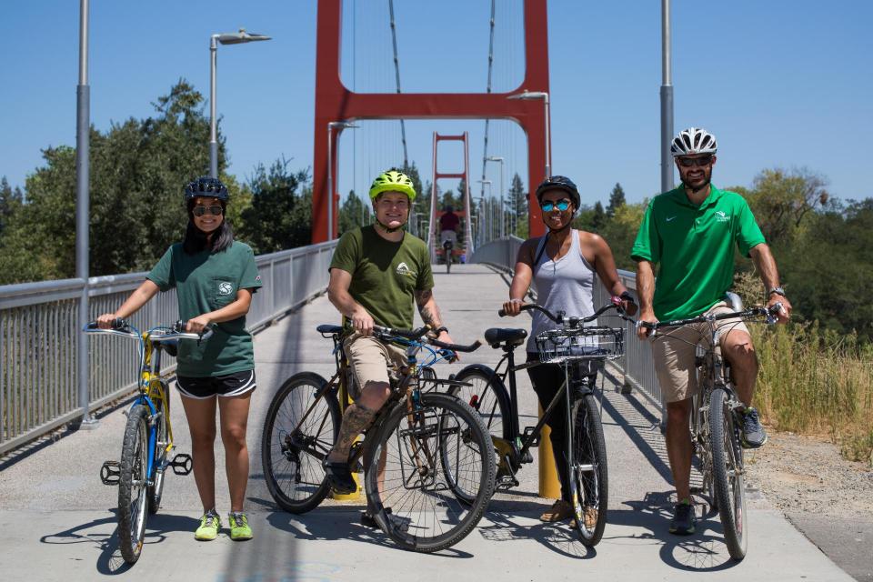 a group of bike riders on the guy west bridge at sac state