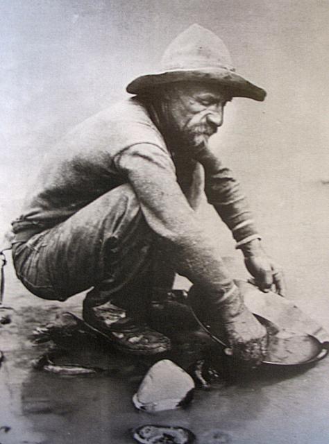 old photo of a gold panner on the american river