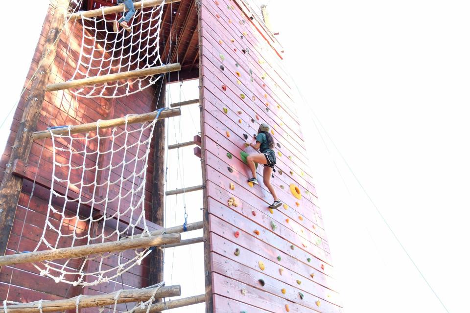 person climbing the rock wall at the challenge center