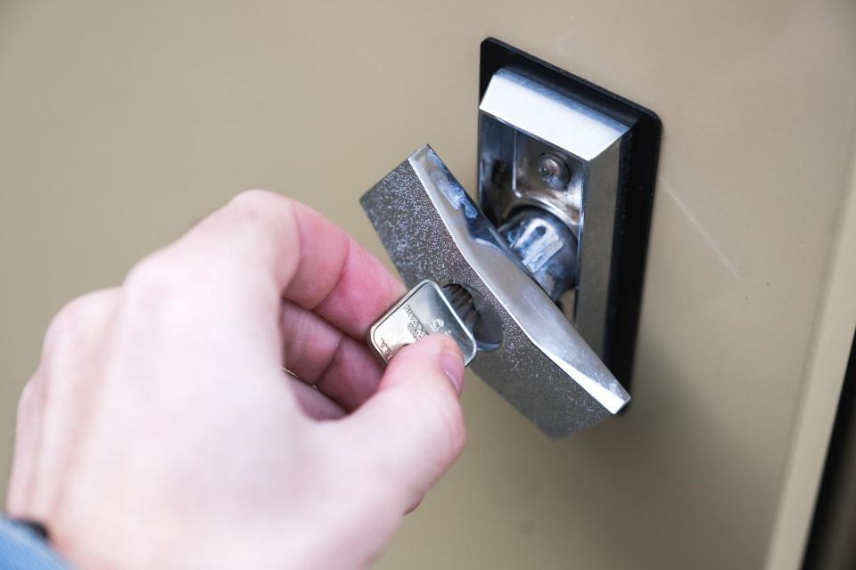 Person opening a bike locker lock.