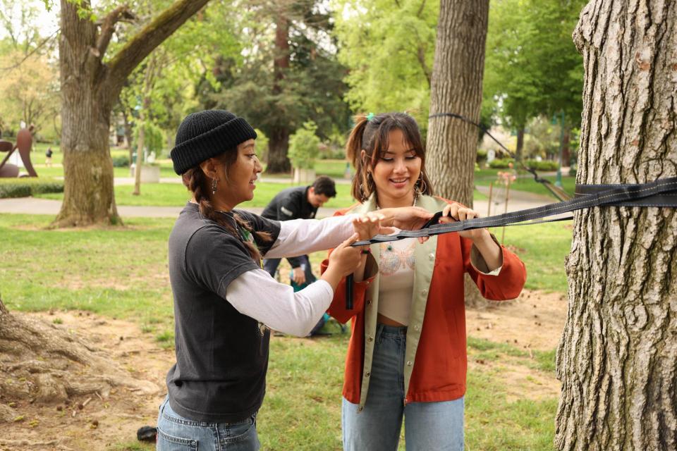 two collehe students setting up a hammock