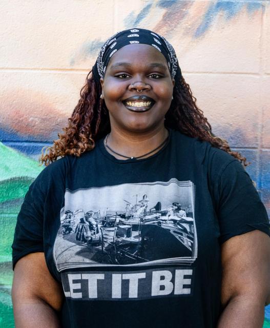 Kay  on front of a mural