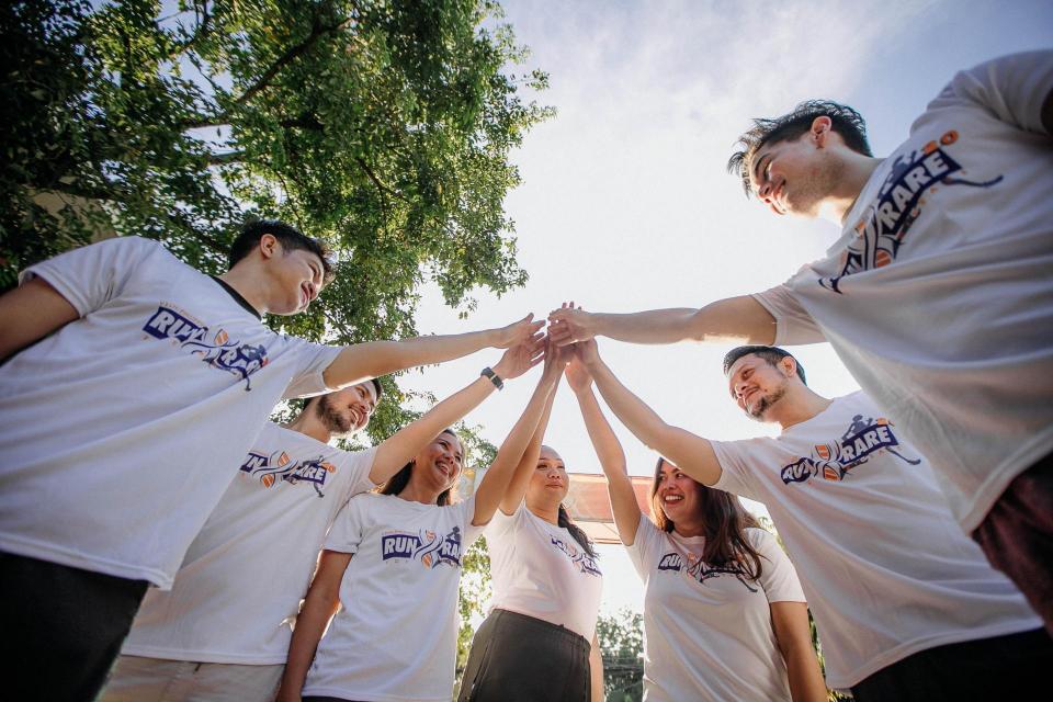 team putting hands into the middle of a circle