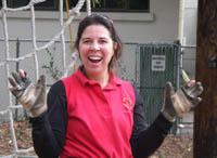 Wendi Weston with gloves in front of a rope course.