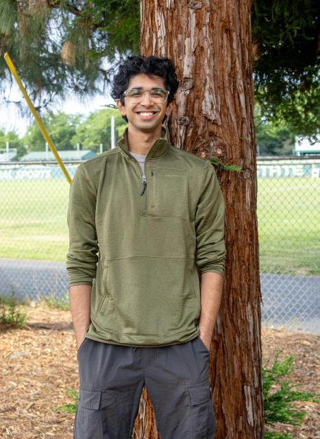 Mehta standing in front of a tree